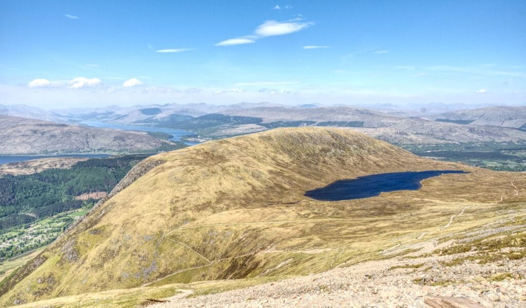 Auf den Ben Nevis wandern in großen Zickzacks auf dem Mountain Path und vorbei an einem See auf halber Höhe.
